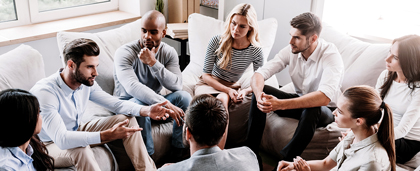 Group Of People Talking In Circle On Couches